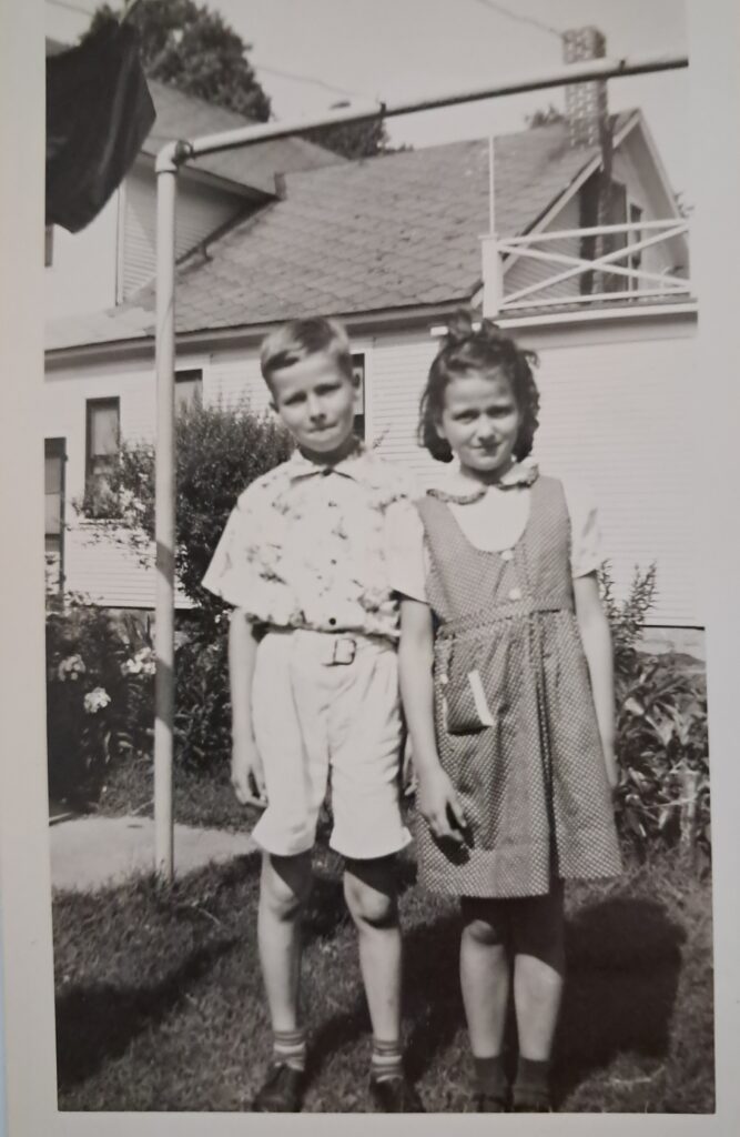 Meg and brother by house in America