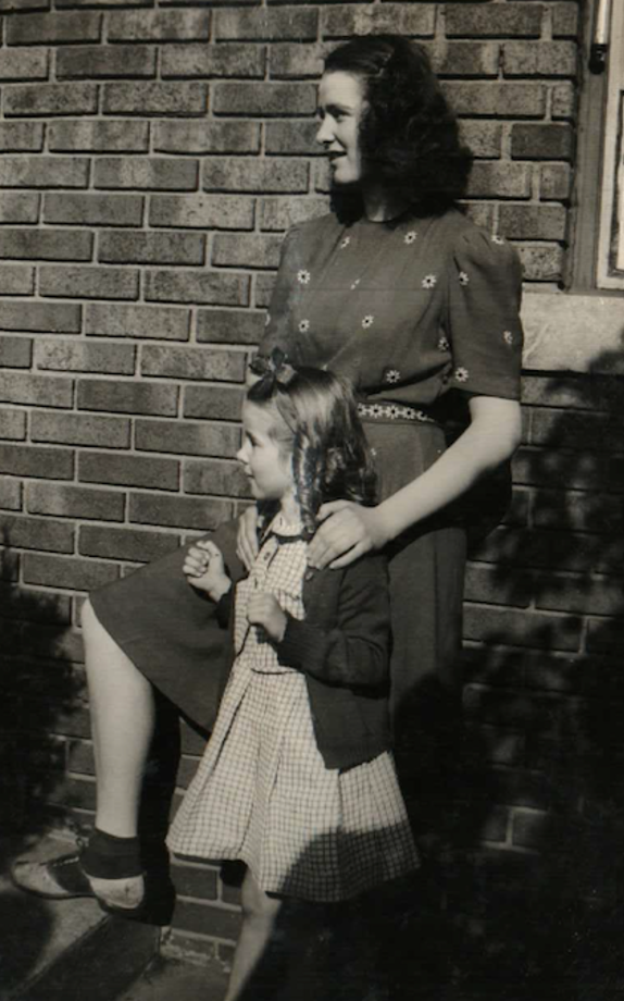 Older sister standing behind younger sister